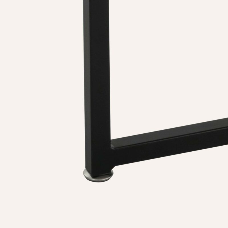 Close-up of black metal leg with silver foot of a modern coffee table.