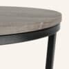 Close-up of a modern nesting coffee table with wooden top and black metal legs.