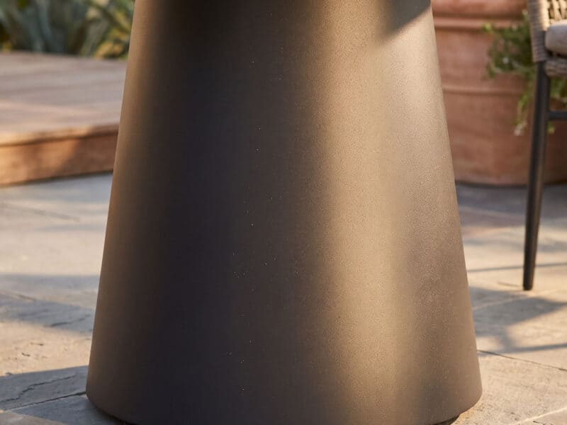 OTF-565 Shadowcircle Charcoal outdoor table base in a garden setting.